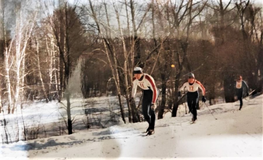 Александр Бибикин (№12) преследует Евгения Асанова из Бийского района в гонке лыжников на 10 км классическим стилем 