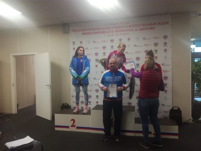 Полина Упирова на первой ступени пьедестала. У его подножия её тренер - Аркадий Конюхов.