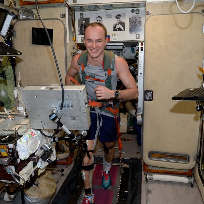 Летчик-космонавт Сергей Рязанский тренируется. Для того чтобы удержаться на беговой дорожке в космосе, нужно надеть специальную жилетку, которая пристёгивается к тренажёру