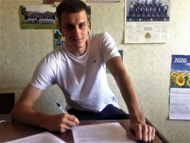 На фото: Ярослав Гусев подписывает свой первый профессиональный контракт