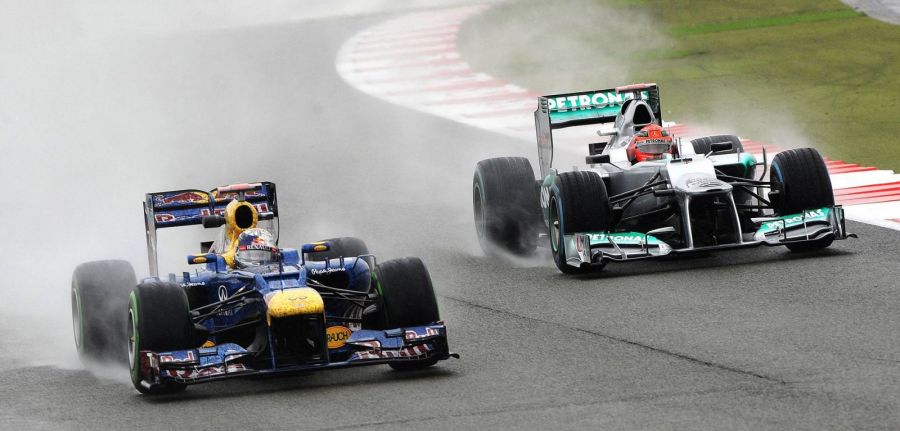 Себастьян Феттель и Михаэль Шумахер на Гран-при Великобритании, 2012 год. Фото: EPA/PETER POWELL